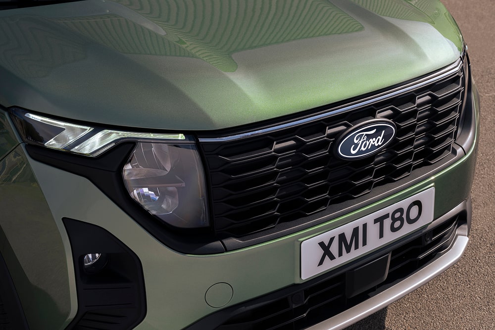Front grille and headlight detail of a green Ford Tourneo Courier MPV.