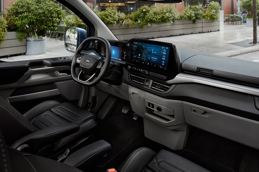 The interior of the Ford Tourneo Custom, showing the driver's seat, dashboard, and central console.