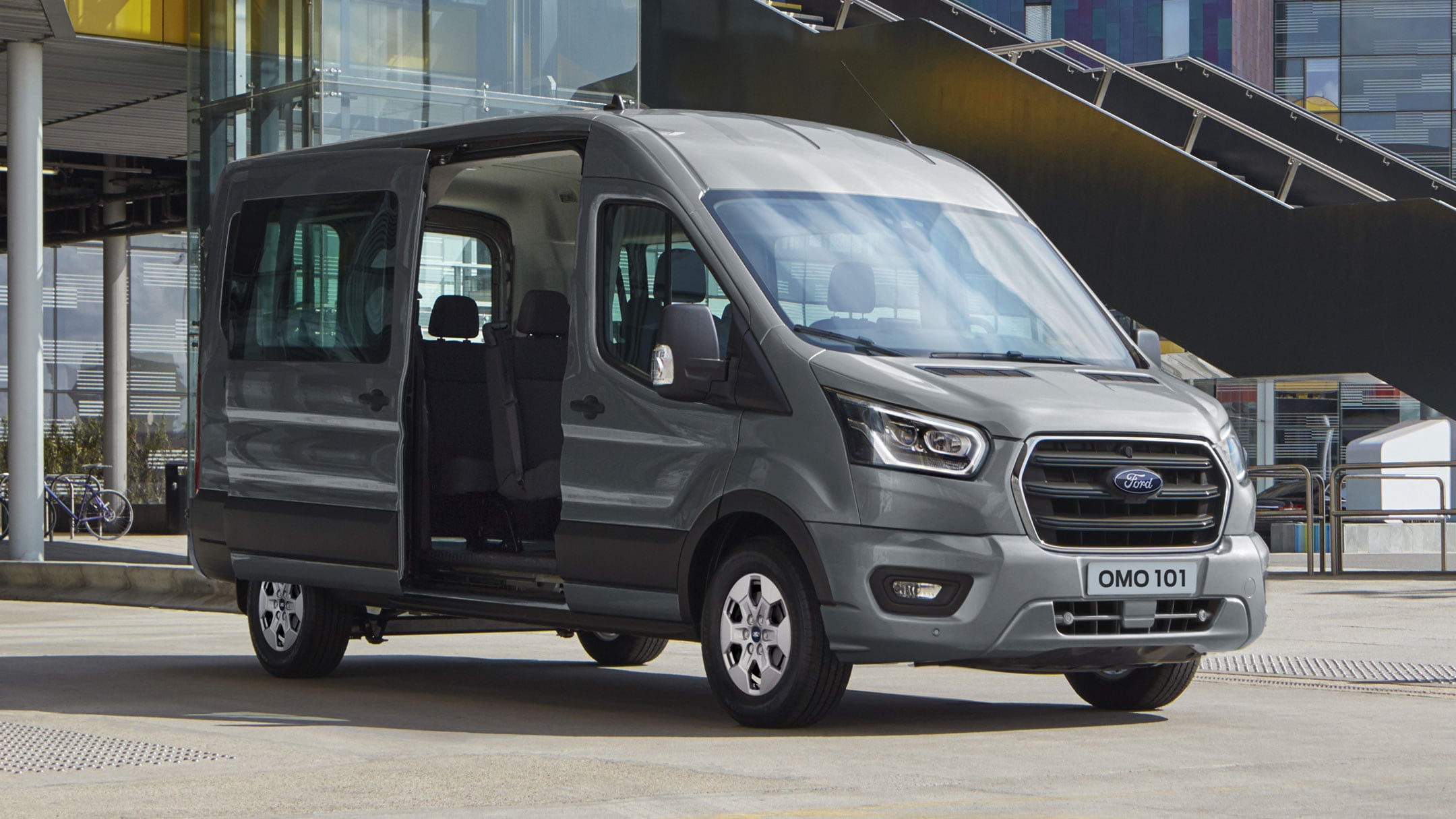 New Ford Transit Minibus parked in front of a modern building with side door open